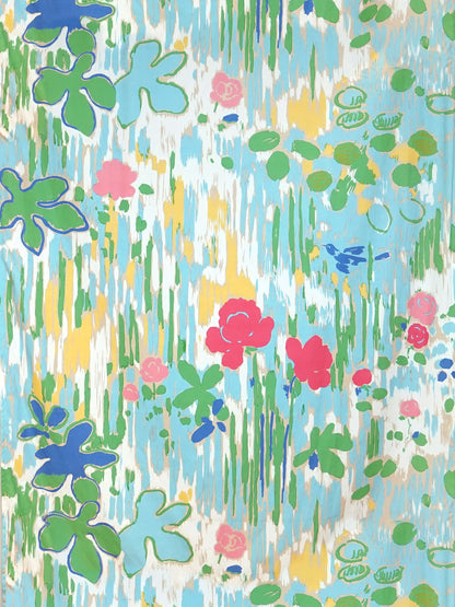 Vibrant abstract floral print with green lily pads, pink/red blossoms, blue water strokes and yellow accents.
