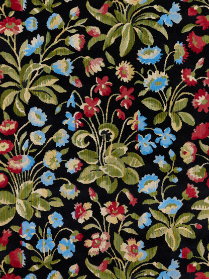 Floral tapestry fabric on black background with blue, red and cream flowers and green leaves.
