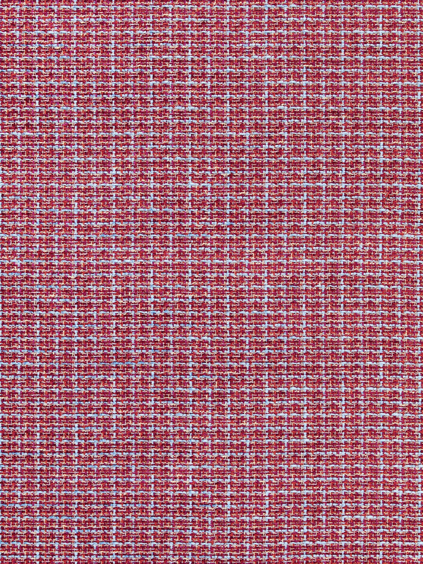 Close-up of red tweed fabric with white & blue flecks; textured woven textile.