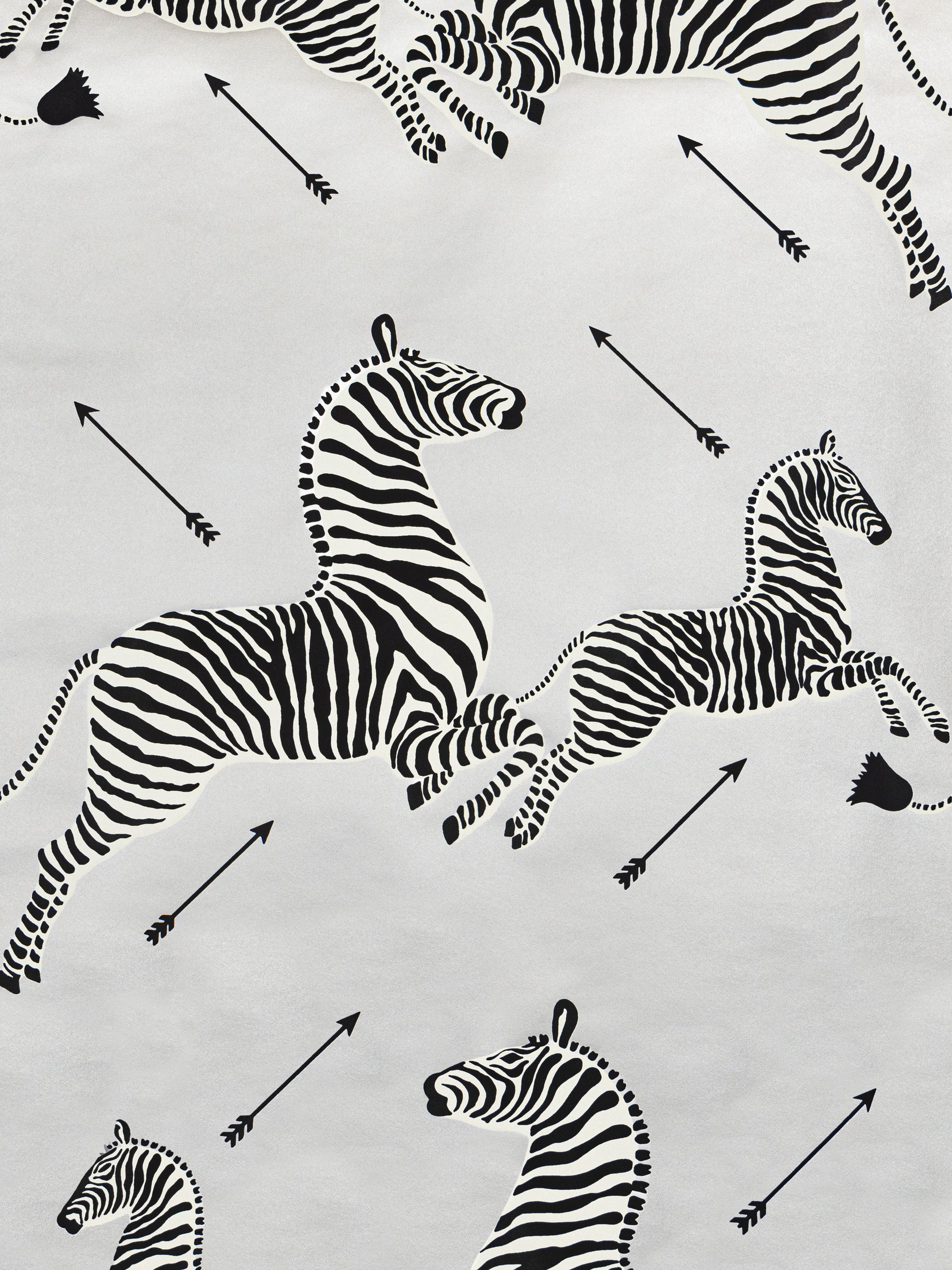 White fabric with black zebra silhouettes and arrows; safari-inspired textile for clothing, crafts, or decor.