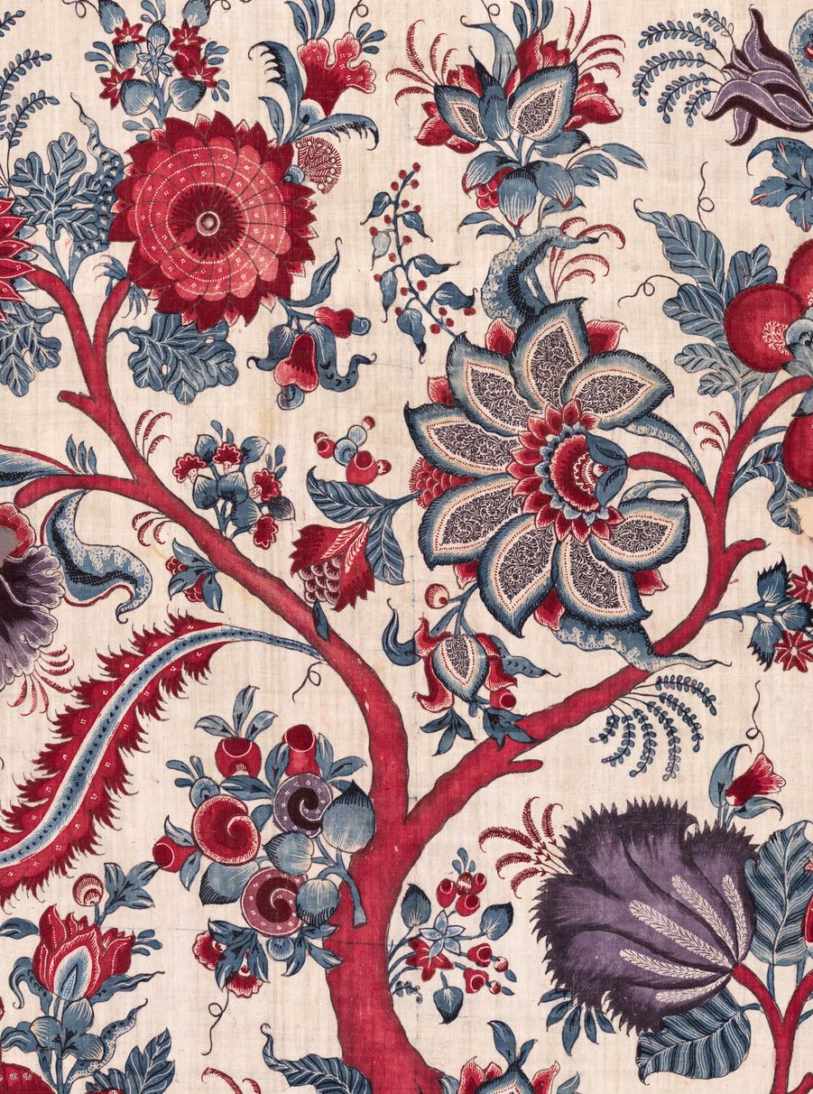 Beige fabric with bold red, blue & purple floral pattern; stylized blossoms, twisting branches & leafy motifs.