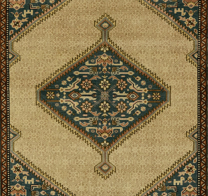Traditional oriental wool rug with beige field, blue diamond medallion, floral motifs, and brown border.