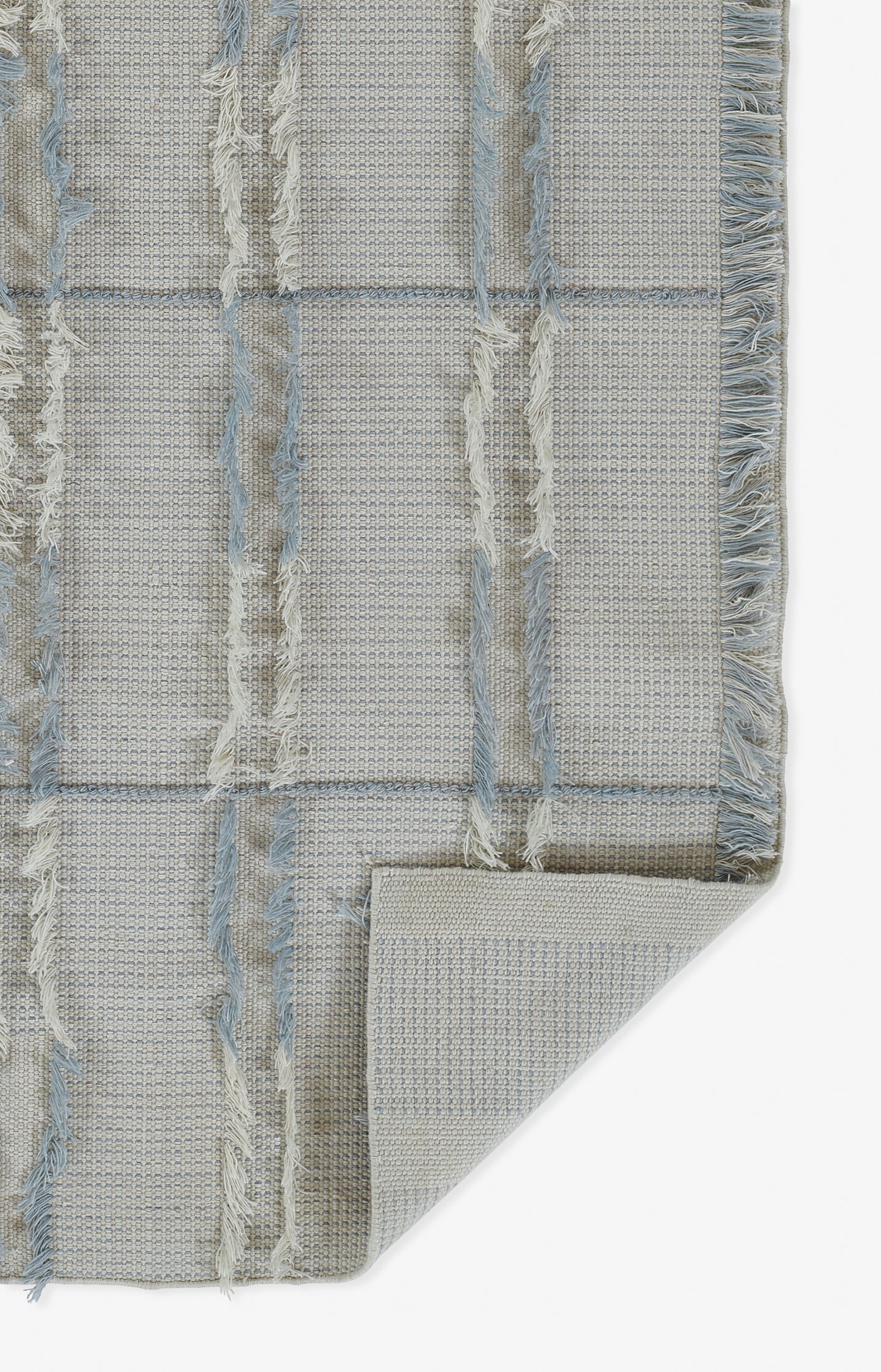 Blue and beige cotton woven rug with vertical fringe stripes, textured grid pattern, folded corner.