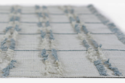Cream flatwoven rug with light blue fringe stripes and a subtle grid pattern