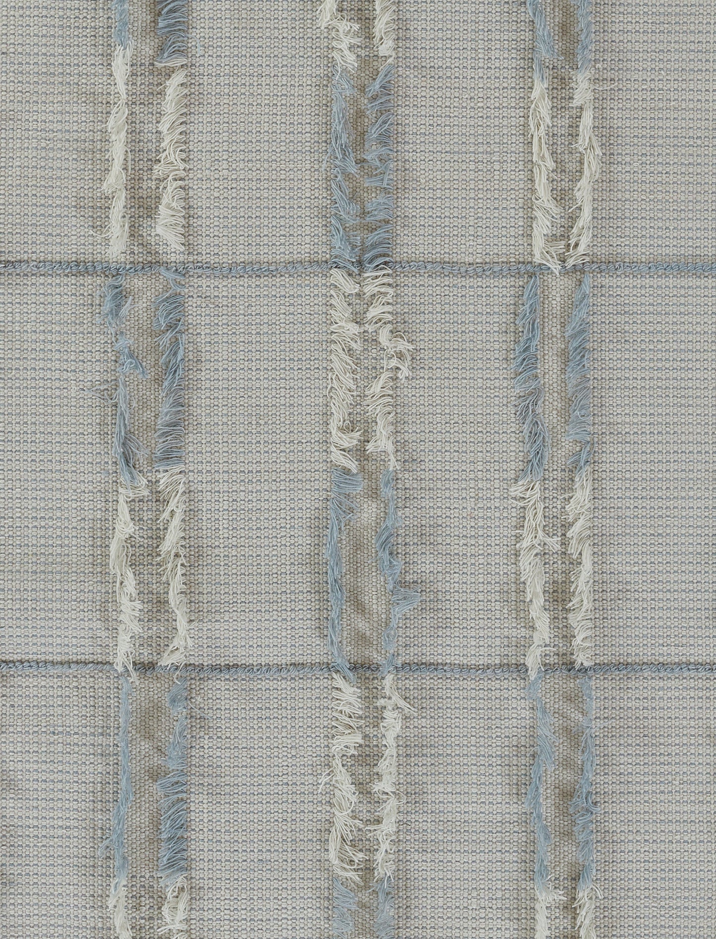 Beige woven rug-like textile with pale blue frayed vertical stripes and fringe, grid-pattern texture