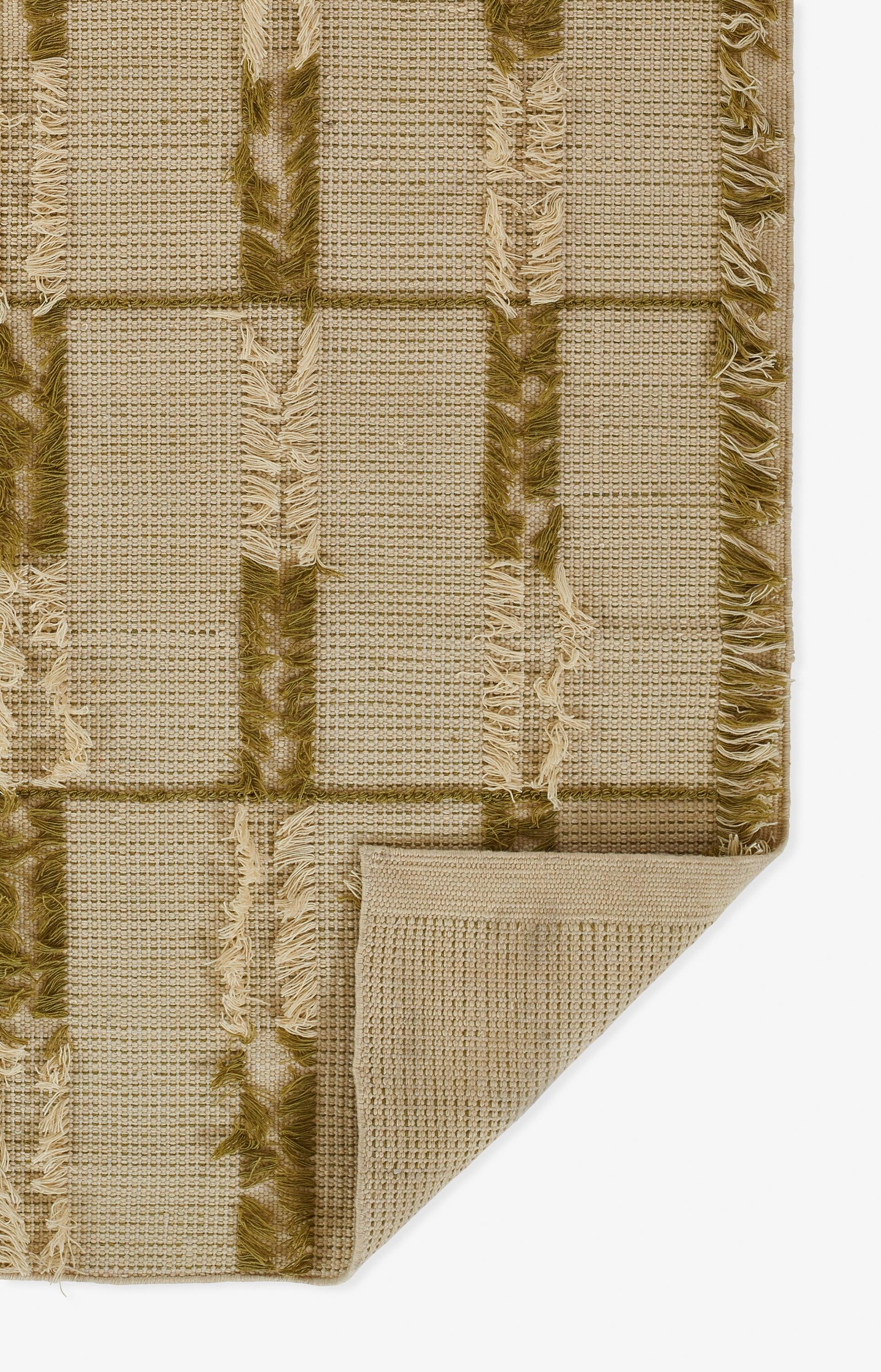 Beige woven rug with olive-green checkered stripes, fringed edges, and a folded corner.