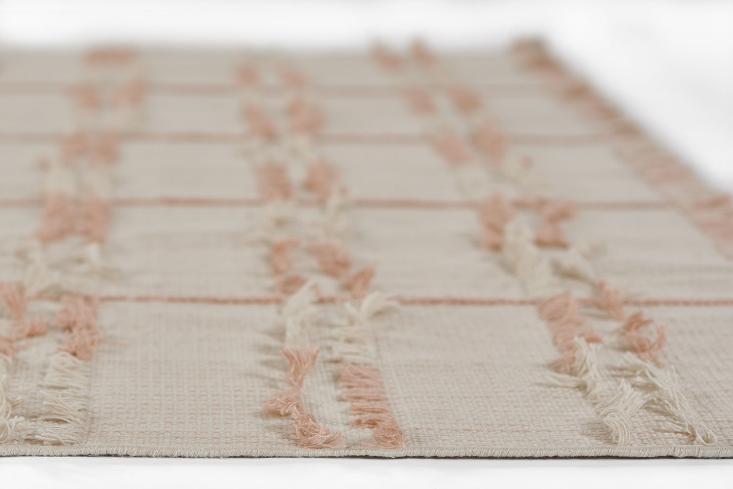 Cream woven runner with pink fringe tassels and pale peach stripes; boho rectangular runner for living room.