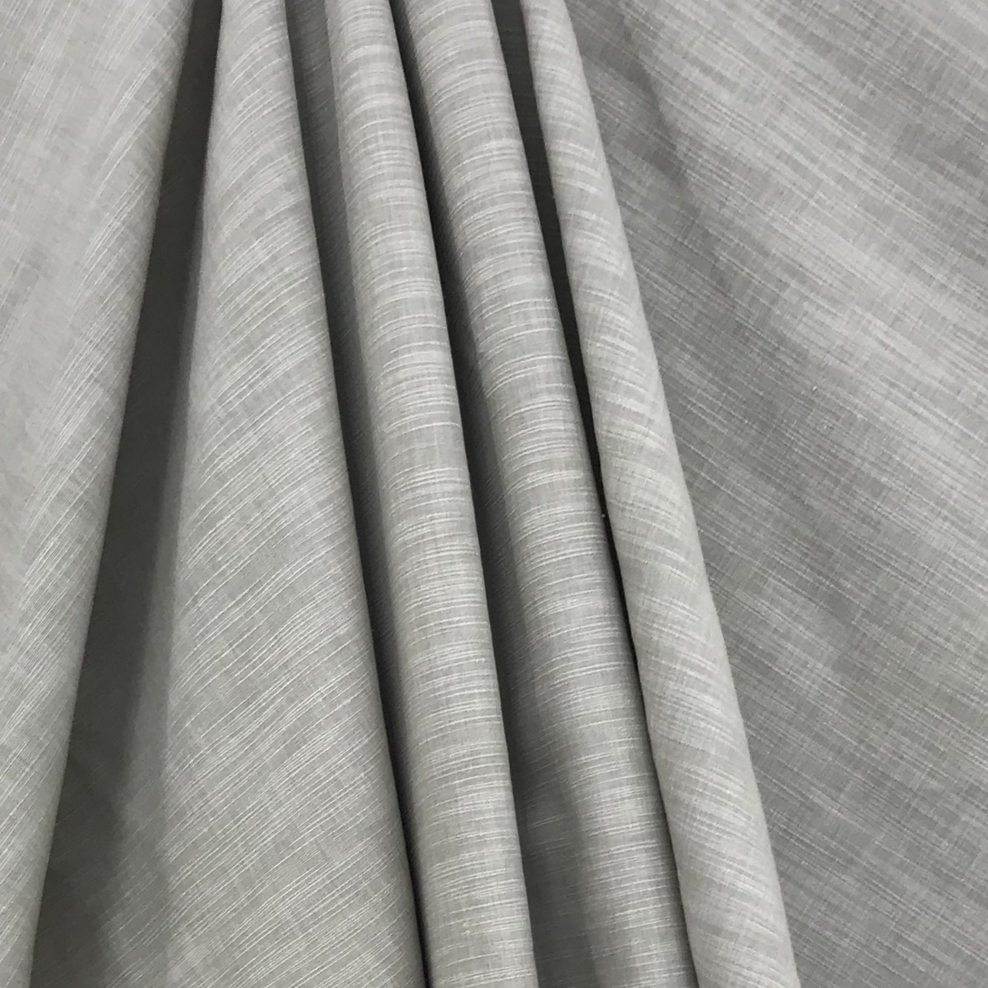 Green shantung fabric draped in folds, showcasing subtle weave and soft, elegant texture; faux silk finish.