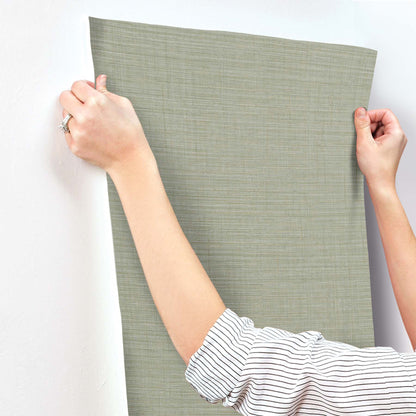 Sage green textured fabric wall panel swatch with linen-like weave, rectangular and held upright.