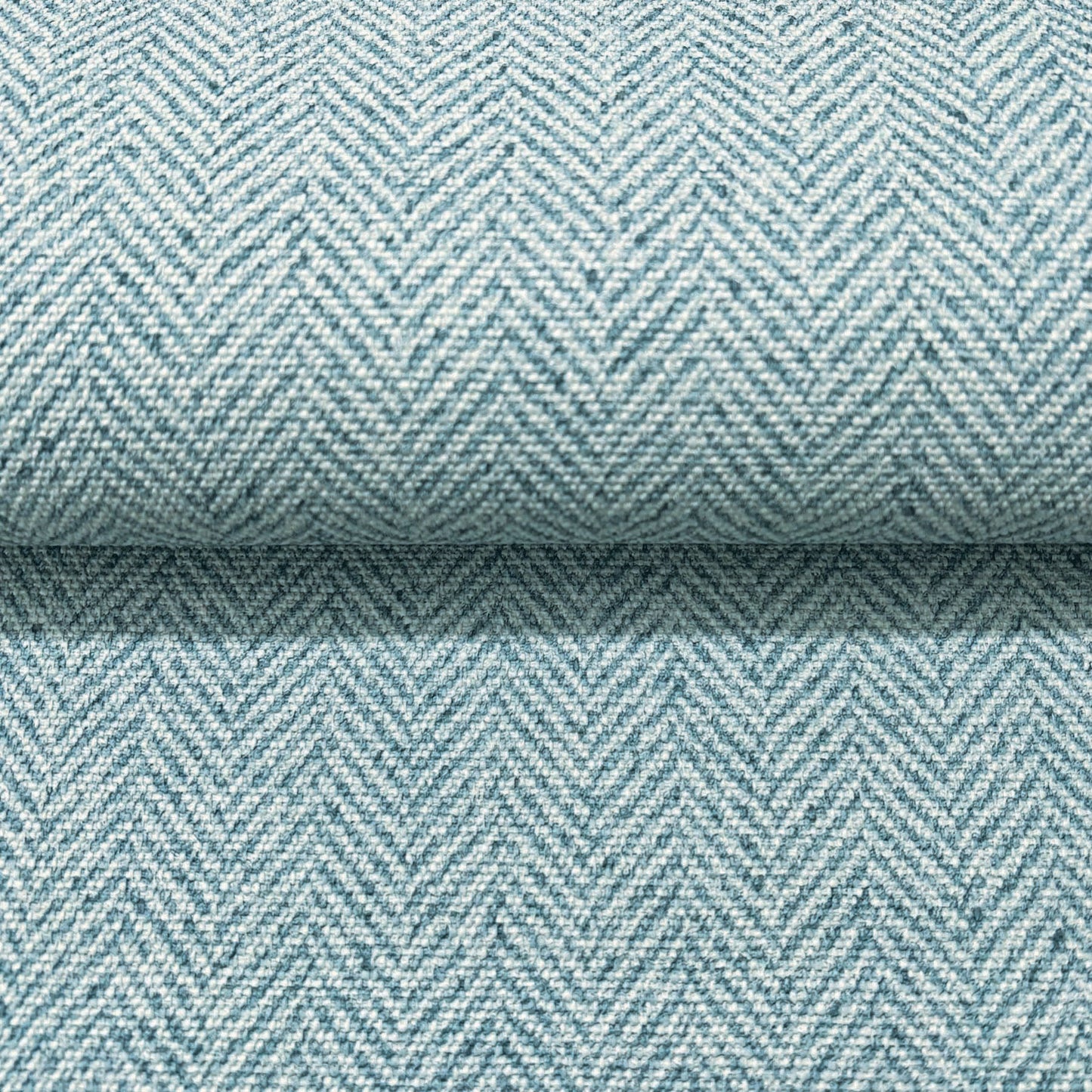Close-up of light blue chevron wallpaper with a subtle woven texture.