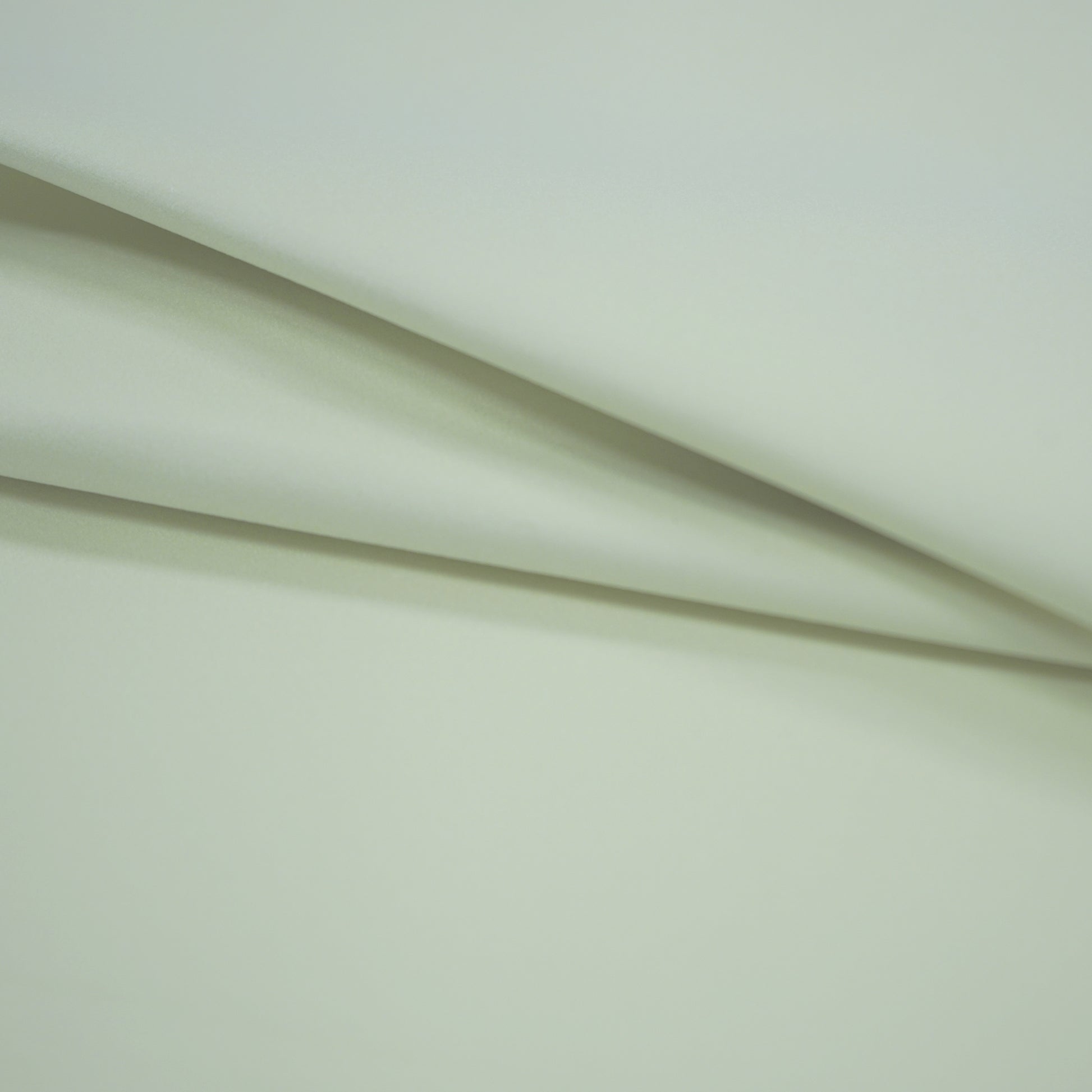 Offwhite fabric with soft diagonal folds and a smooth surface.