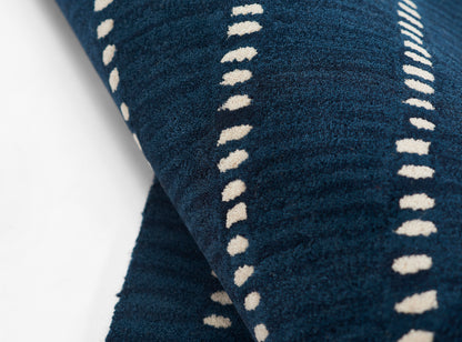 Navy blue rug with cream dotted stripe pattern and plush pile.