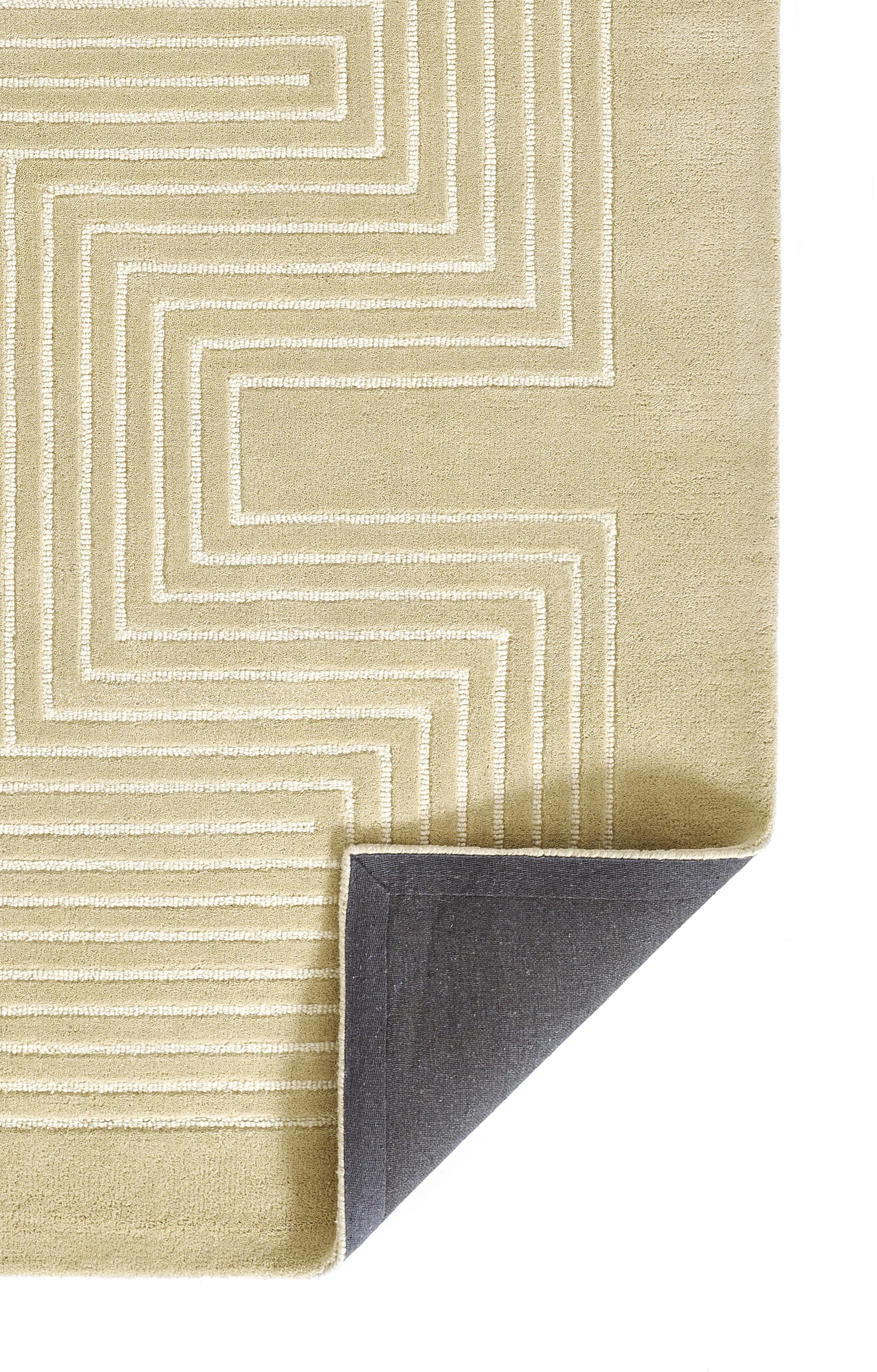 Beige rug with white geometric maze pattern; folded corner reveals dark gray backing.