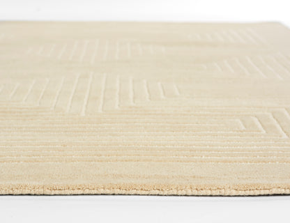 Beige low-pile rug with a subtle geometric rectangular pattern and soft edge for neutral home decor