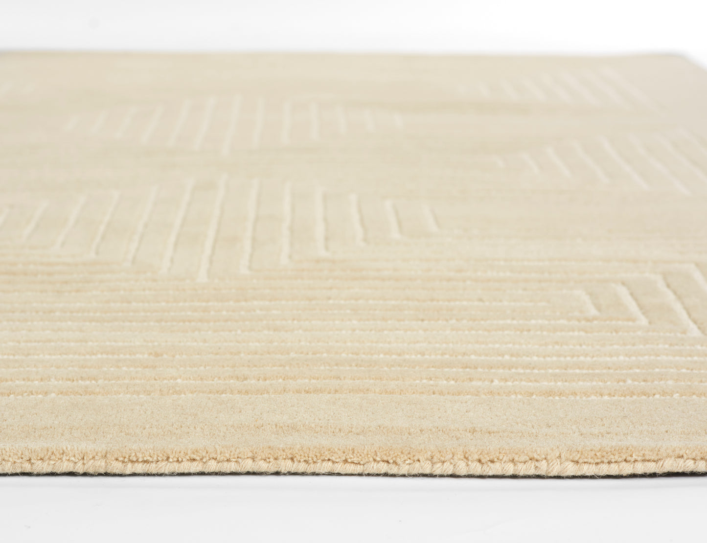 Beige flat-weave rug with a subtle geometric rectangular pattern and a soft edge, low-pile look.