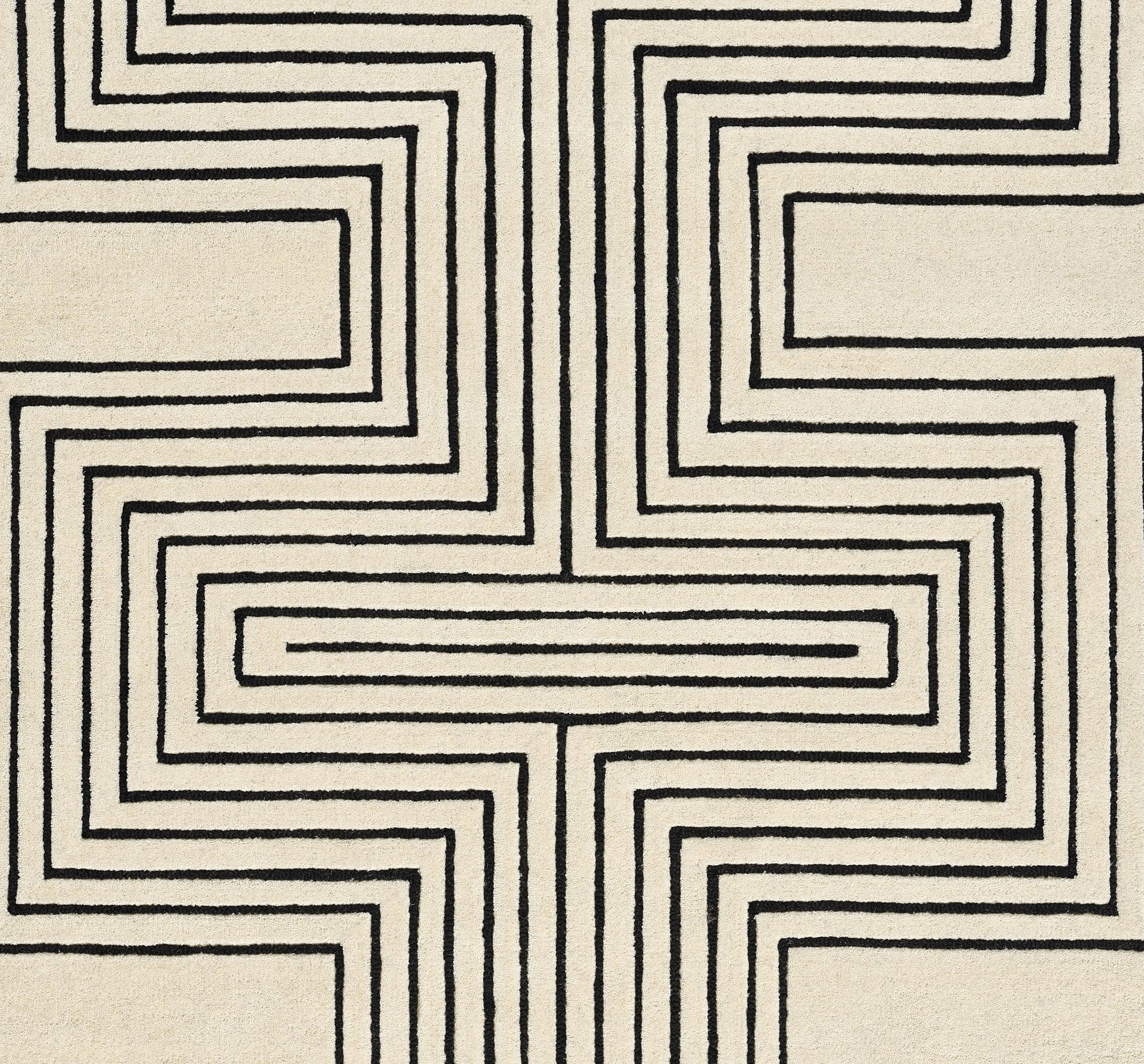 Beige rug with bold black geometric maze pattern forming a symmetric cross motif.