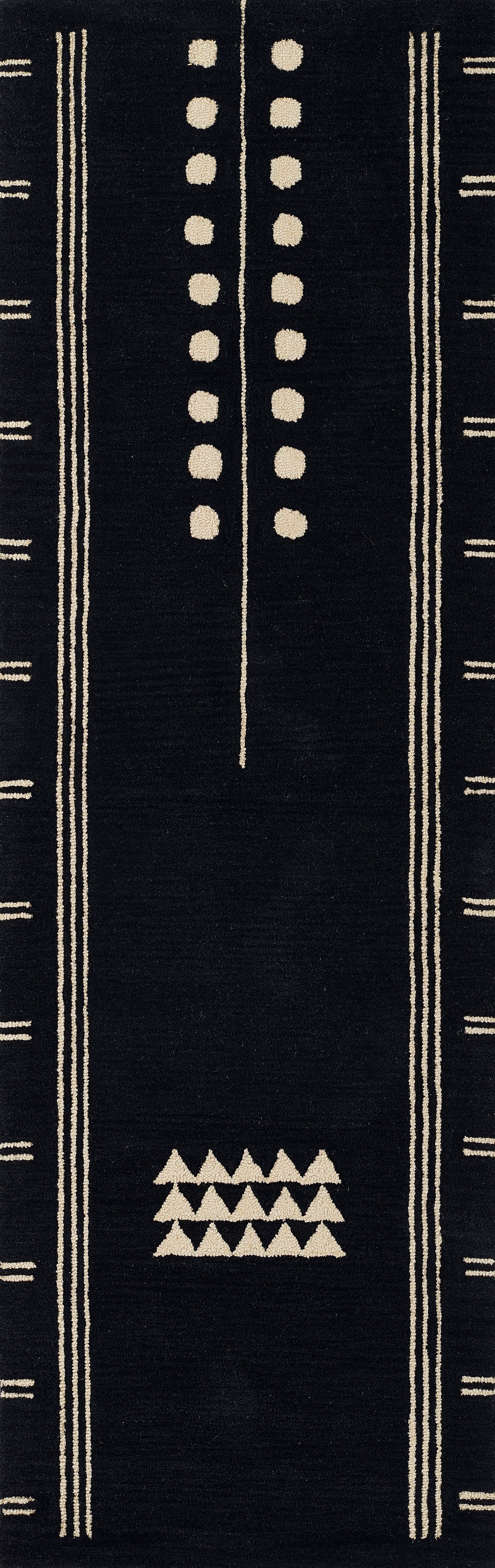 Black woven area rug with beige geometric patterns: vertical border stripes, dotted center line, and stacked triangle motif.