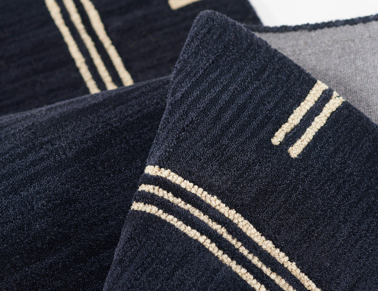 Navy blue terry towels with cream striped accents; plush bath linens for home use.