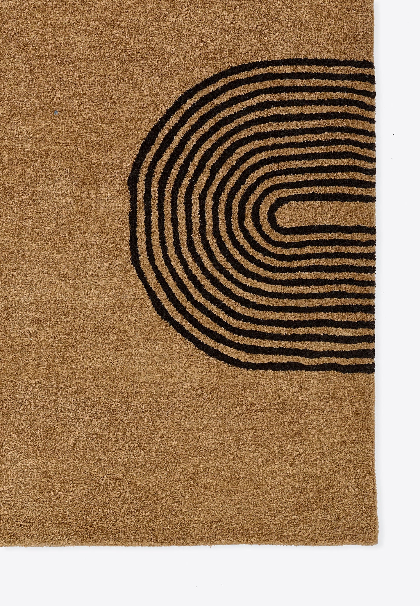 Tan rug with black concentric curved lines forming a partial circle on the right; natural fiber, geometric design.