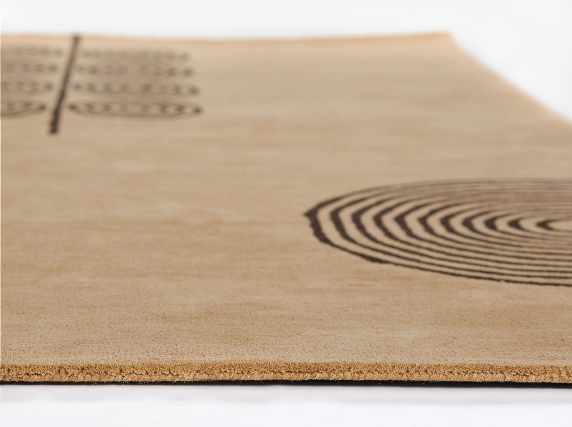 5' x 8' rug packaged on brown kraft board with black concentric fingerprint rings and partial vertical text along the left edge.