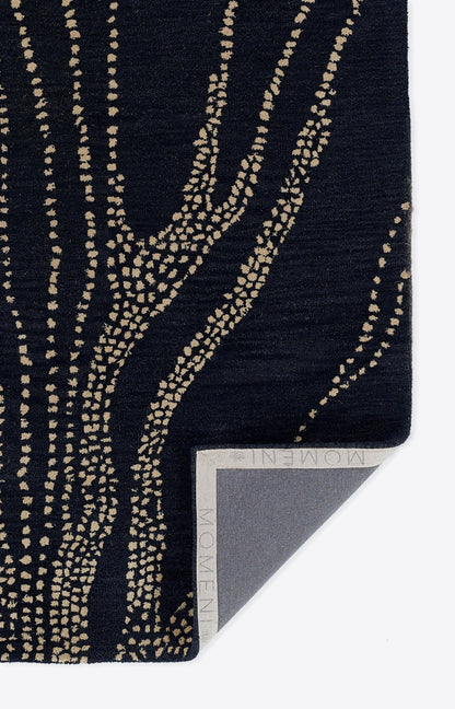Navy scarf with beige dotted tree-branch pattern; woven fabric, rectangular, folded corner reveals gray label.