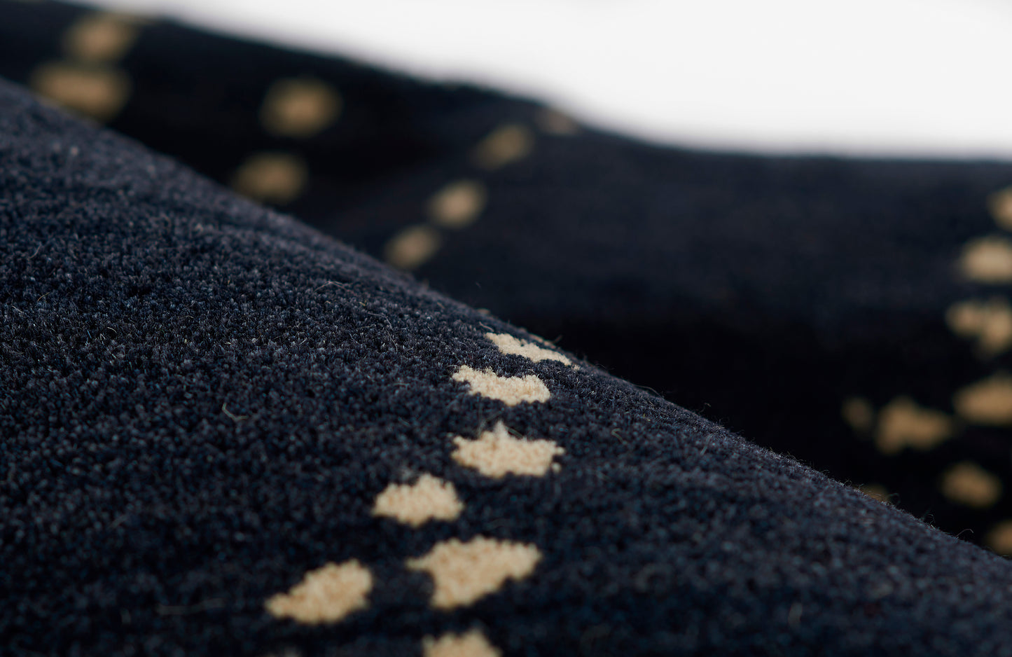 Navy blue knit rug runner, 2'6" x 8', with a tiny beige diamond pattern along the edge; soft, textured surface.