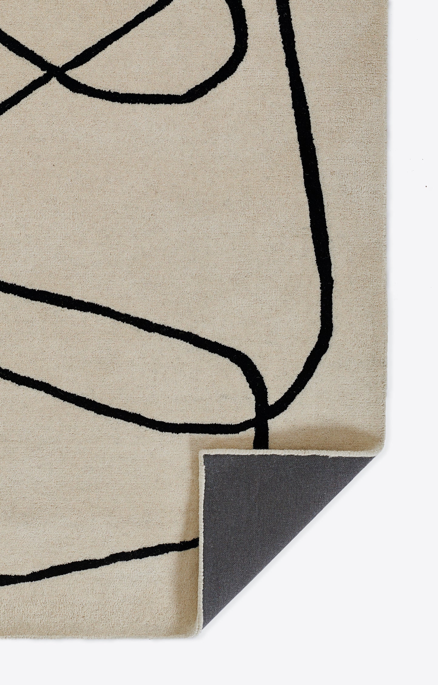 Beige rug with abstract black line drawing; folded corner reveals grey underside.