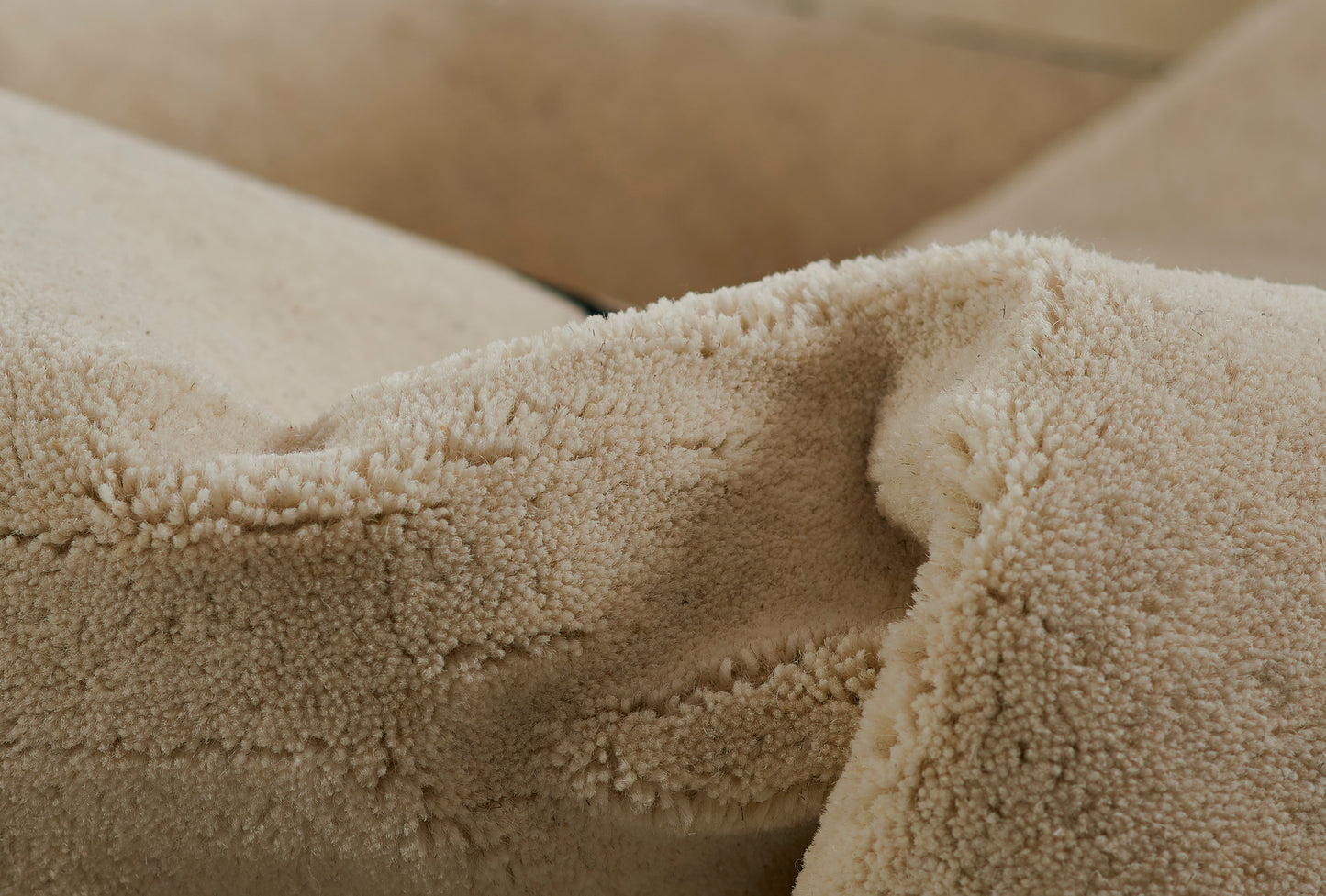 Beige rug runner with plush, textured sherpa fleece-like pile; close-up of fabric.