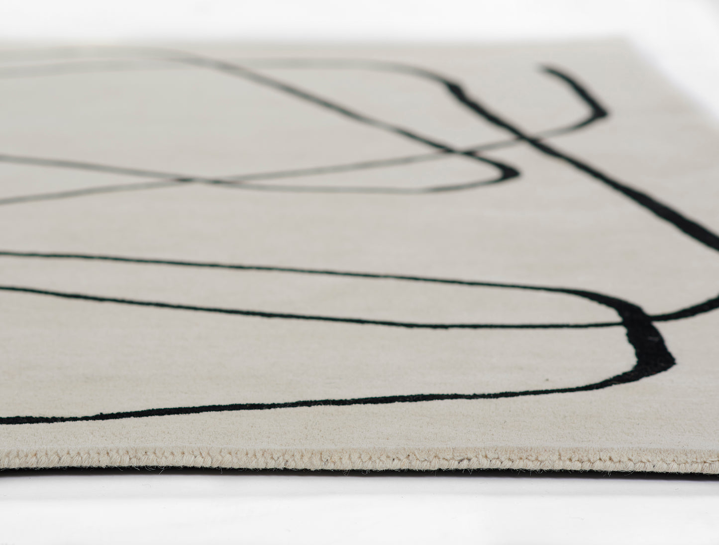 Beige area rug with abstract black curved lines, modern minimalist design.
