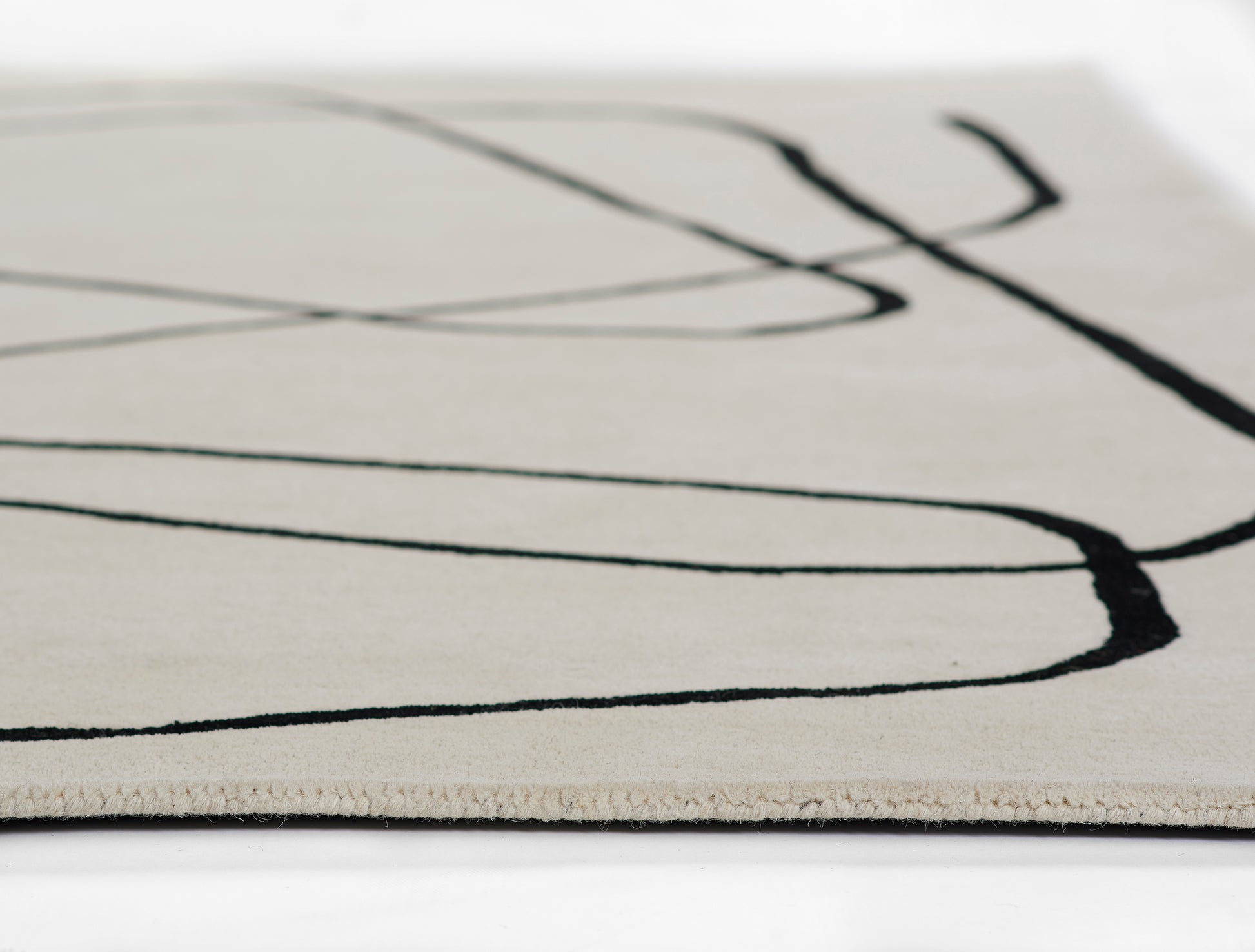 Beige runner rug with bold black abstract lines; modern minimalist flat-weave texture, ideal for contemporary living spaces.