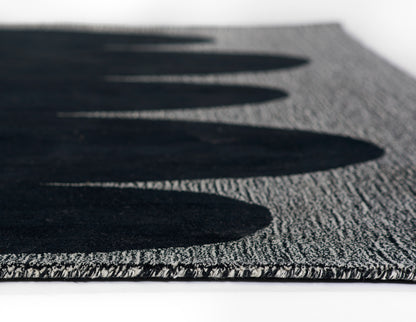 Gray textured runner rug with bold black oval pattern along the edge; looped pile, modern geometric style; 2'6" x 8'.