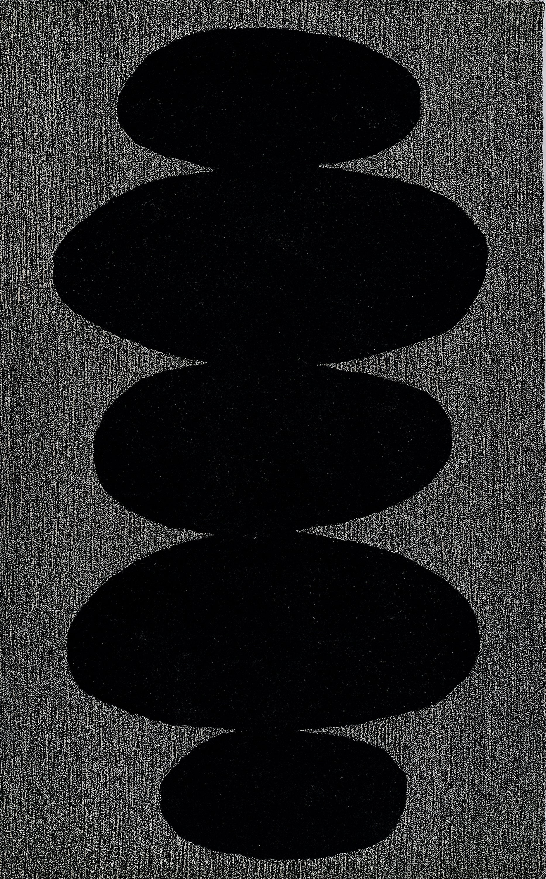 Stack of smooth black stones arranged vertically on a textured dark gray background.