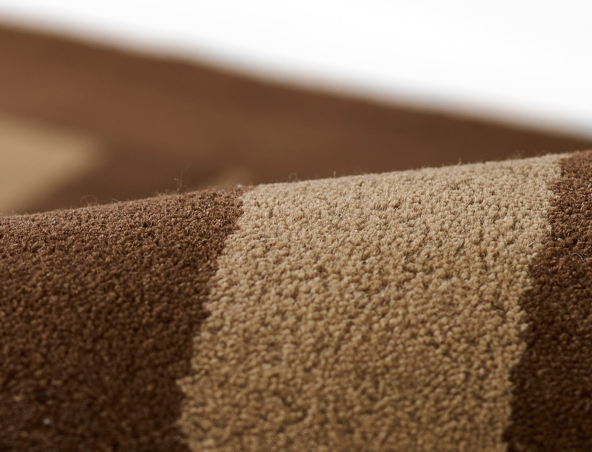 Close-up of brown and beige striped plush rug with soft, thick pile.