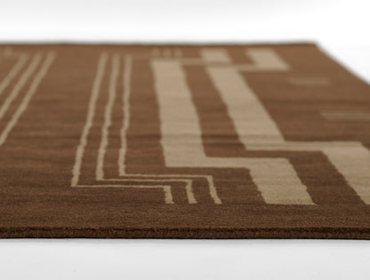 Brown rug with beige geometric line pattern, close-up edge view.