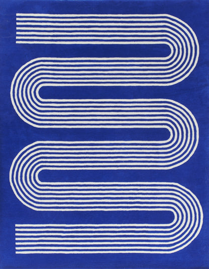 Blue textile with white parallel curved stripes forming an elongated S; modern geometric rug or wall art.