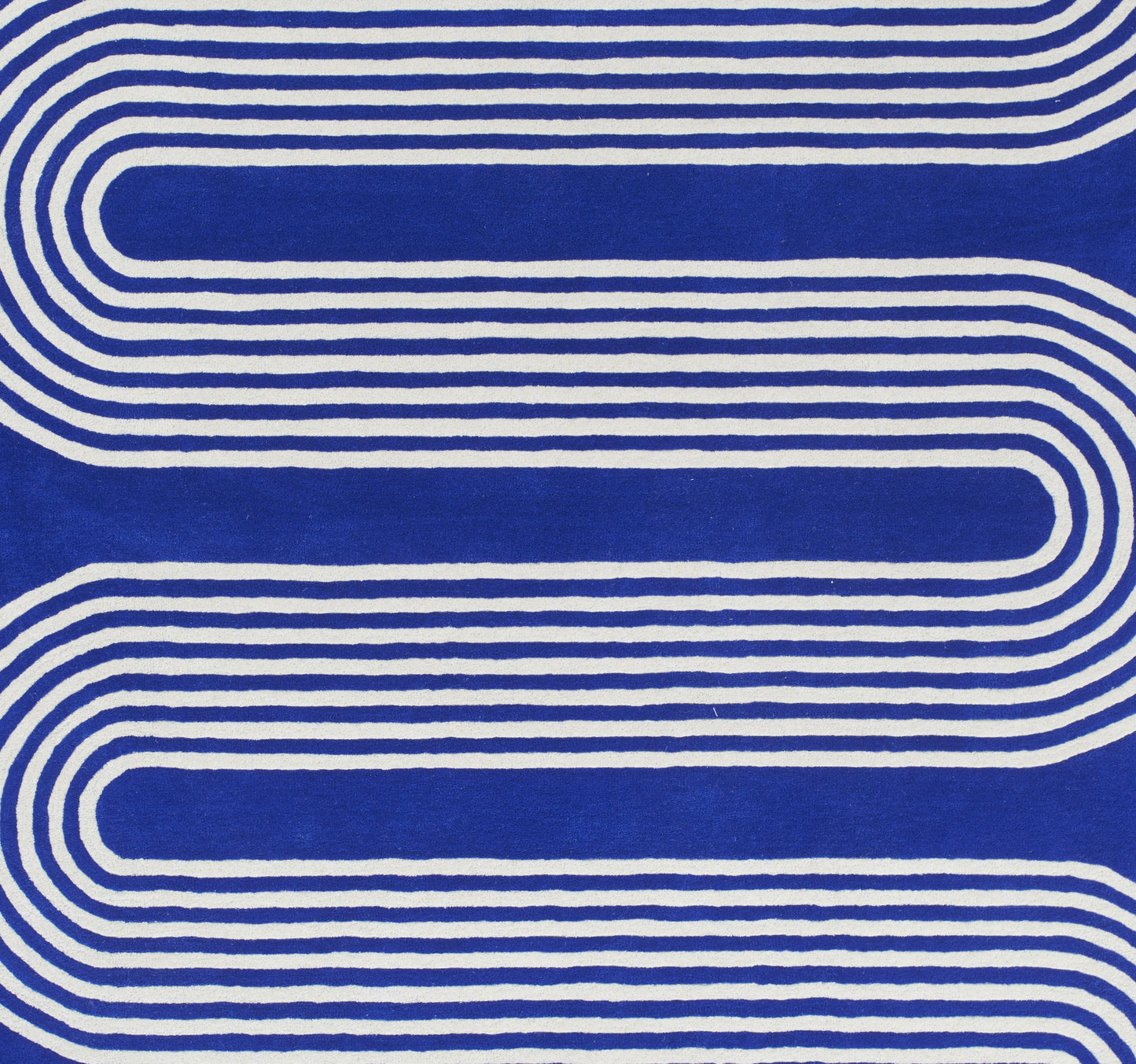 Blue rug with white curved looping stripes and an abstract geometric pattern; size 9' x 12'.