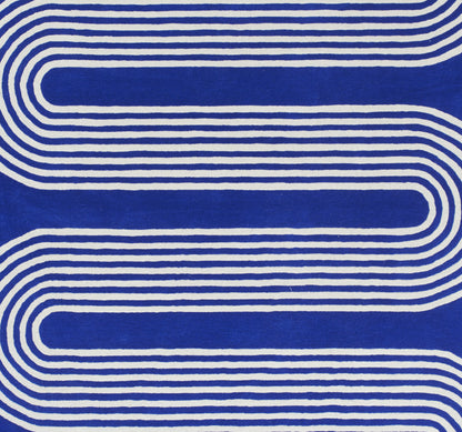 Blue rug with white curved looping stripes and an abstract geometric pattern; size 9' x 12'.