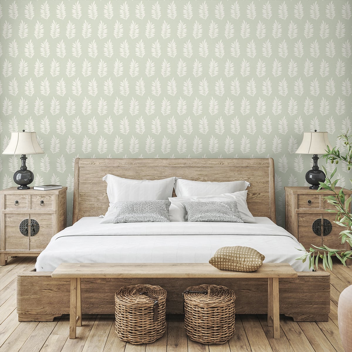 Rustic wooden bed with white bedding, two nightstands, bench at foot, wicker baskets, leafy wallpaper and lamps.