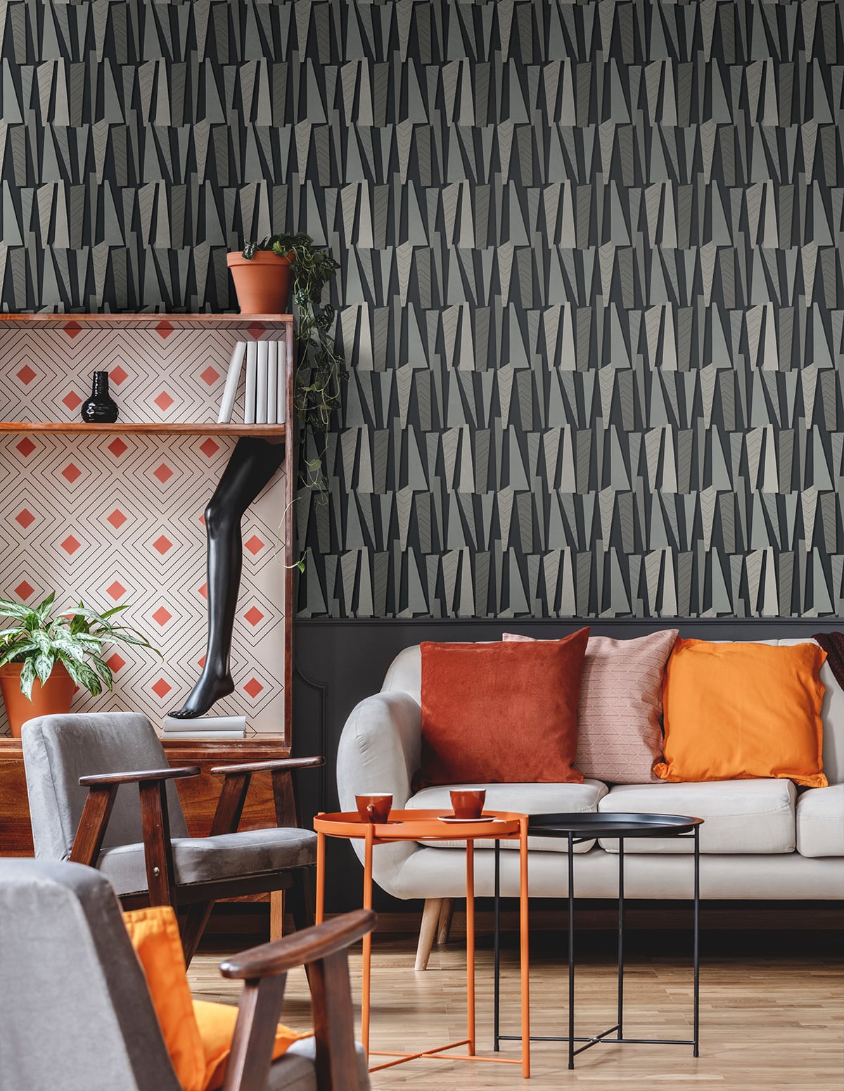 Modern living room with grey geometric wallpaper (grey matte), gray sofa with orange cushions, orange tables, and black nesting tables.