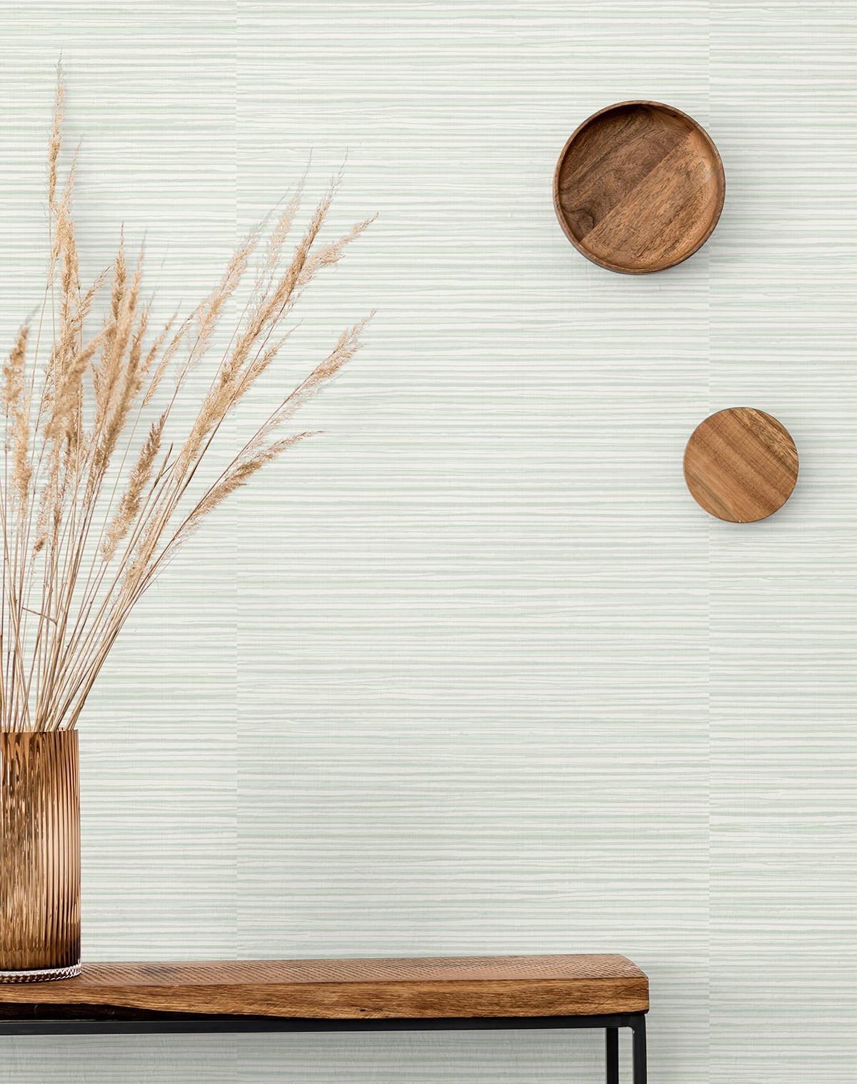 Striped green matte wall art on a light striped wall with two round wooden wall decor discs.