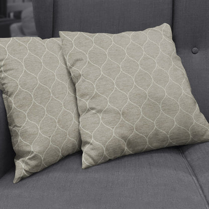 Two beige square decorative cushions with white interlocking curved-line pattern on a dark gray sofa.