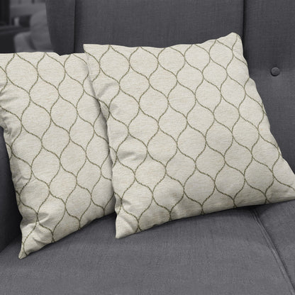 Beige square throw pillows with taupe curved lattice pattern on a gray fabric sofa.