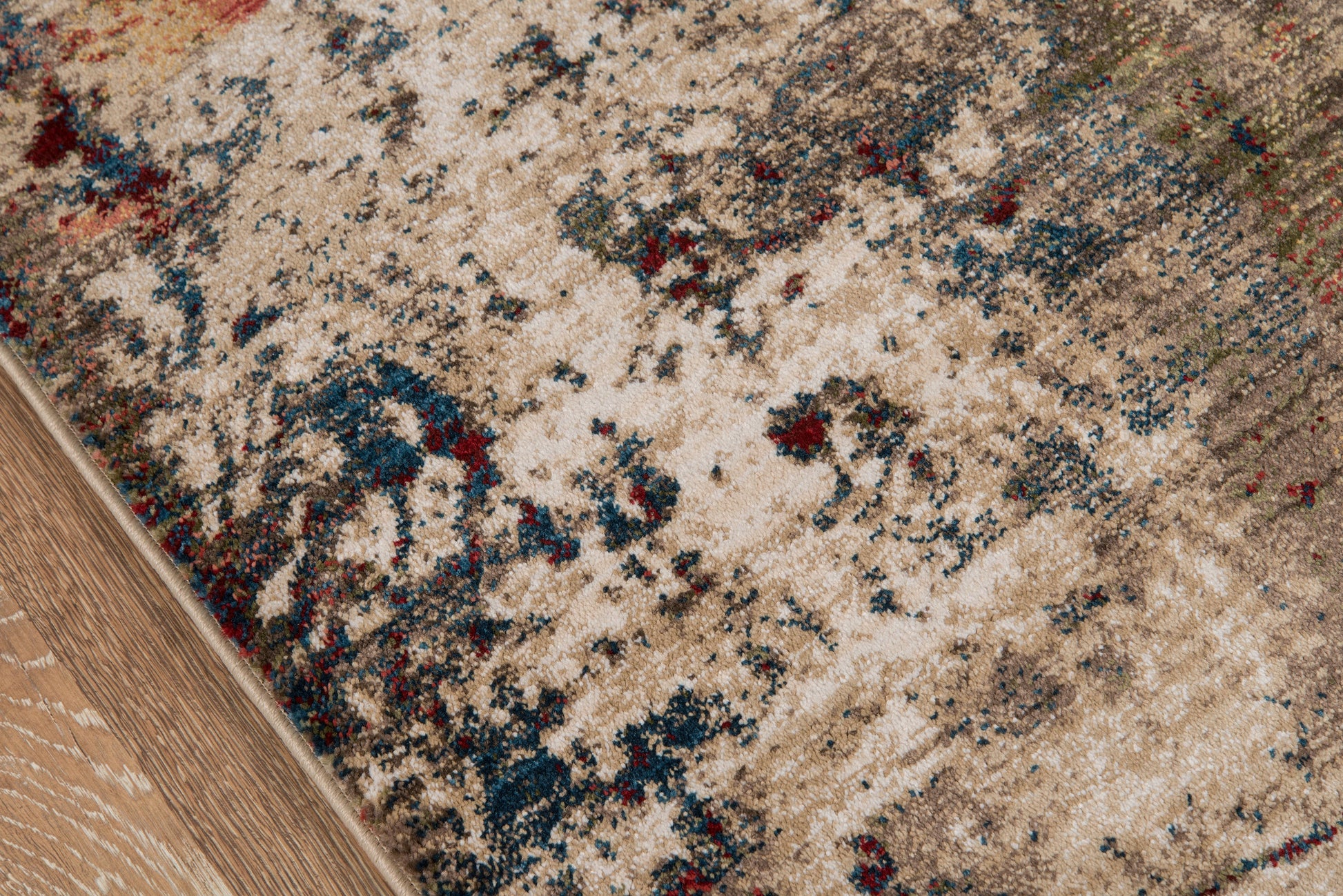 Beige distressed runner rug with blue, red and green accents on a wooden floor; vintage Persian-inspired pattern, 2'X8'.