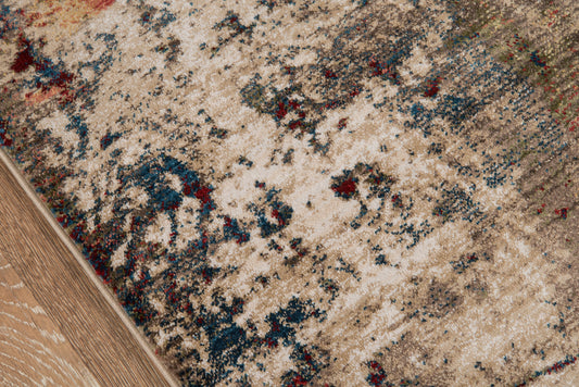 Beige distressed area rug with blue and red accents on a wood floor; abstract vintage style.