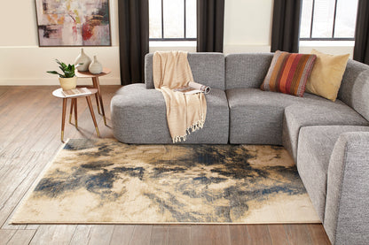 Gray fabric sectional with beige throw & multicolor pillow on blue-beige abstract rug in a modern living room.