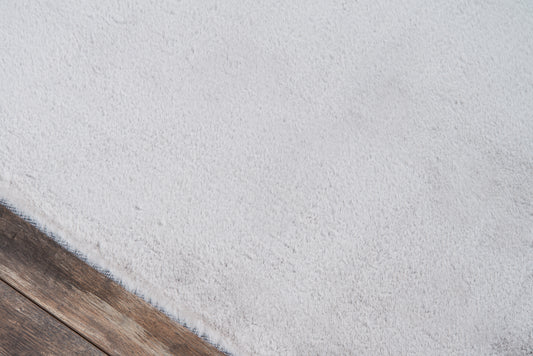 Soft light-gray shag area rug, 5' x 7', with subtle texture on dark wood flooring.