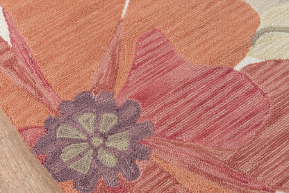 Close-up of a textured floral rug with orange, pink and purple petals and a lavender-green center.