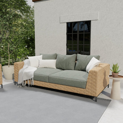 Outdoor beige wicker sectional sofa with olive-green cushions, white pillows, and a light throw on a patio.