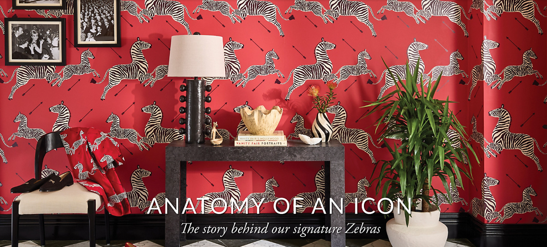 Decorative room with red wallpaper featuring zebra patterns, a table with decorative items, and a plant.