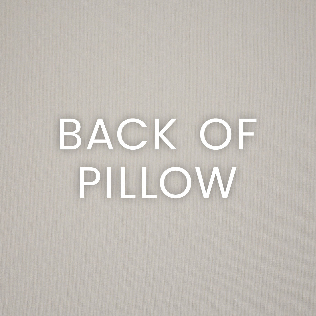 Back of pillow label in white bold letters on an eggshell beige textured backdrop.